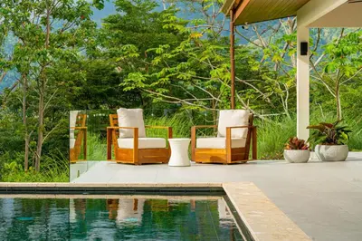 a group of chairs sitting next to a swimming pool at Casa Grande del Mar - by Pura Villas in Punta Mala