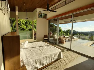 a bedroom with a bed and a large window at Casa Grande del Mar - by Pura Villas in Punta Mala