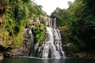 a waterfall in the middle of a forest at Hacienda Jaguar - by Pura Villas in Ojochal