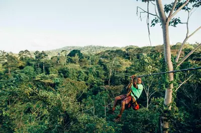 a woman on a zip line in the jungle at Hacienda Jaguar - by Pura Villas in Ojochal