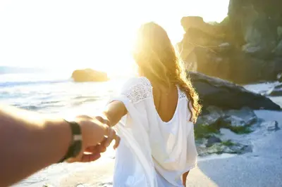a man and woman holding hands while walking on the beach at Hacienda Jaguar - by Pura Villas in Ojochal