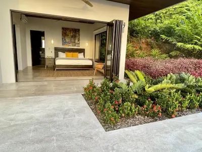 a view of a bedroom with a bed and some plants at Casa ReSol - by Pura Villas in Uvita