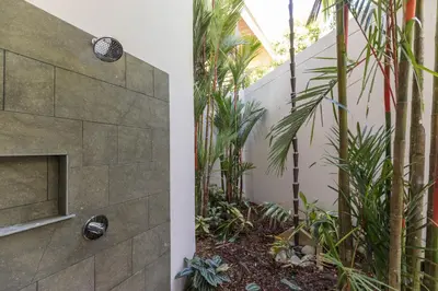 a bathroom with a stone shower with plants at Casa ReSol - by Pura Villas in Uvita