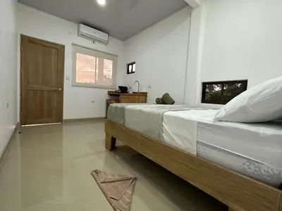 a bedroom with a large bed and a door at Tuanis Guest House in Tortuguero