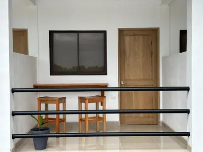 a glass counter in a room with two stools at Tuanis Guest House in Tortuguero