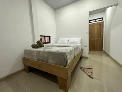 a bedroom with a bed with a teddy bear on it at Tuanis Guest House in Tortuguero
