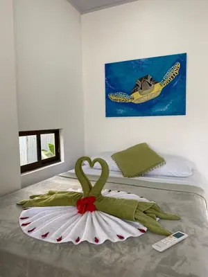a bedroom with a bed with a towel on it at Tuanis Guest House in Tortuguero