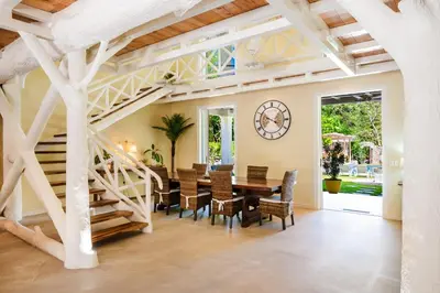 a dining room with a table and chairs and a staircase at Villa Harmonia in Potrero