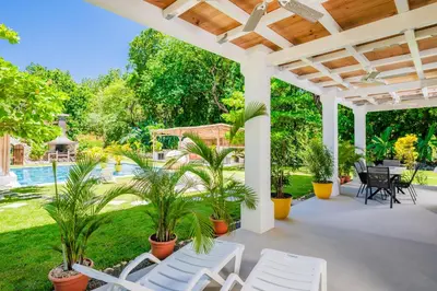 an outdoor patio with white chairs and plants at Villa Harmonia in Potrero