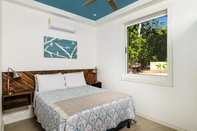 a bedroom with a bed and a window at Buendía Lux Mango Suite Stylish Retreat with Pool Near Beach in Potrero