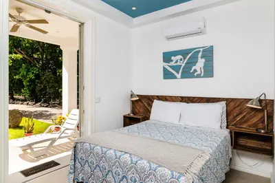 a bedroom with a bed and a door to a patio at Buendía Lux Mango Suite Stylish Retreat with Pool Near Beach in Potrero