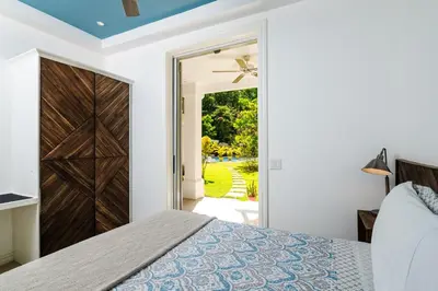 a bedroom with a bed and a sliding door at Buendía Lux Mango Suite Stylish Retreat with Pool Near Beach in Potrero