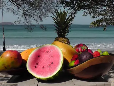 a pile of fruit in wooden bowls on the beach at Plaza Mercado 22 At Las Catalinas in Playa Danta