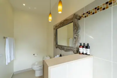 a bathroom with a mirror and a toilet at Casa Harmonia- 2 Br House With Pool in Potrero