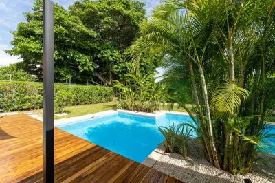 a swimming pool in a garden with a wooden deck at Casa Harmonia- 2 Br House With Pool in Potrero