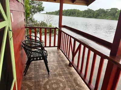 two chairs sitting on a balcony overlooking a body of water at Cabinas Tortuguero Sports Fishing in Tortuguero