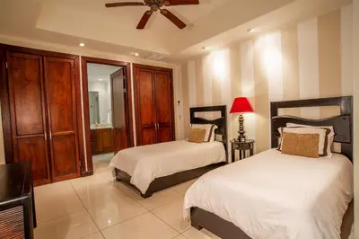 a bedroom with two beds and a ceiling fan at Adults Only 3BR Condo with Partial Ocean View - Carao - Reserva Conchal in Playa Conchal