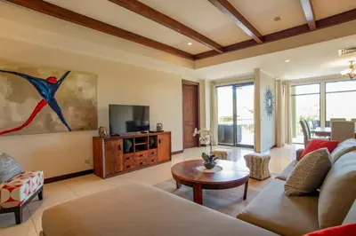 a living room with a couch and a tv at Adults Only 3BR Condo with Partial Ocean View - Carao - Reserva Conchal in Playa Conchal
