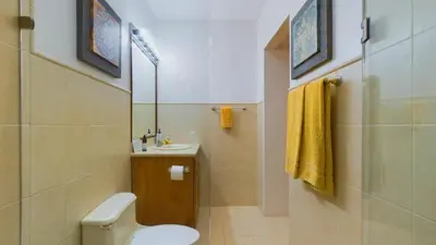 a bathroom with a toilet and a sink and a mirror at Casa Tropical, Spacious 3 Bedroom Home in Brasilito