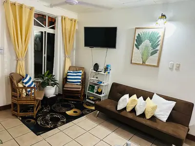 a living room with a couch and a tv at Mahale House - Manuel Antonio, Quepos in Quepos