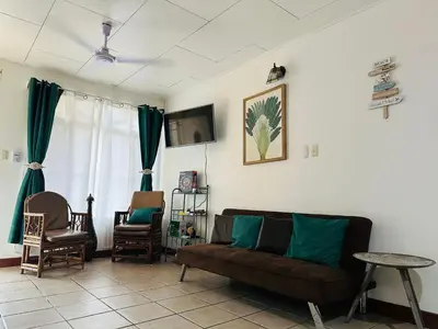 a living room with a couch and chairs and a tv at Mahale House - Manuel Antonio, Quepos in Quepos