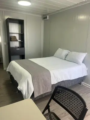 a room with a bed and a chair in it at Hotel Hospedaje Alto Lechuza Zarcero in Zarcero