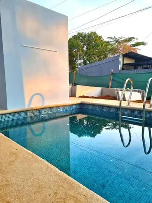 a swimming pool with blue water in front of a building at Casa Mar de Sueños Tamarindo in Tamarindo