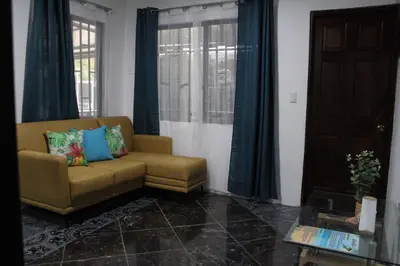 a living room with a couch and a window at Casa Chu en Playa Manuel Antonio in Manuel Antonio