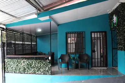 a blue building with two chairs and a table at Casa Chu en Playa Manuel Antonio in Manuel Antonio