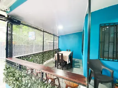 a room with a table and chairs and a blue wall at Casa Chu en Playa Manuel Antonio in Manuel Antonio