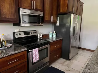 a kitchen with a stove and a stainless steel refrigerator at Casa Famari at Playa Bejuco in Bejuco