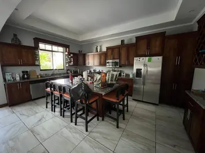 a kitchen with a table with chairs and a refrigerator at Casa Famari at Playa Bejuco in Bejuco
