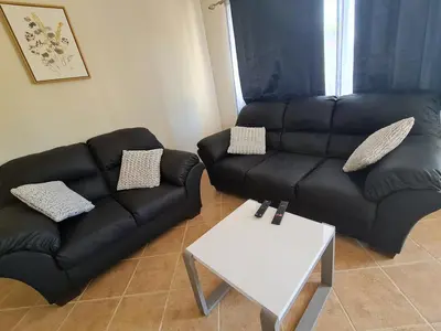 a living room with a black couch and a table at JFM Apartamento in Coco