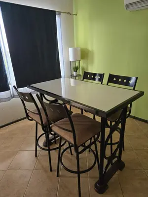a dining room table with chairs and a table with a lamp at JFM Apartamento in Coco