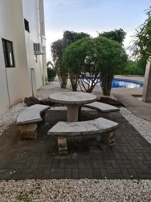a patio with a table and benches next to a building at JFM Apartamento in Coco