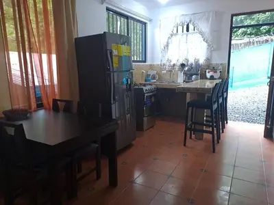 a kitchen with a table and a refrigerator at Casa Eli en Playa Manuel Antonio in Quepos