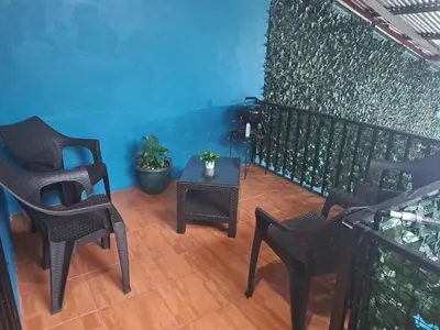 a balcony with chairs and a table and a wall at Casa Eli en Playa Manuel Antonio in Quepos