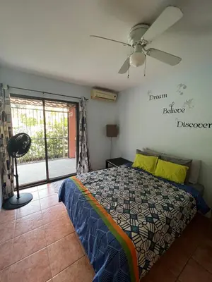 a bedroom with a bed and a ceiling fan at Mariposa End Unit Loft in Coco