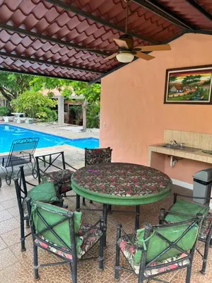 a patio with a table and chairs and a pool at Mariposa End Unit Loft in Coco