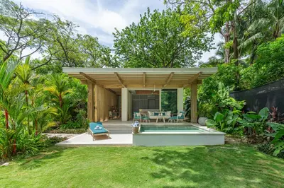 a backyard with a swimming pool and a house at New Beachfront House - Casa Aura in Santa Teresa Beach