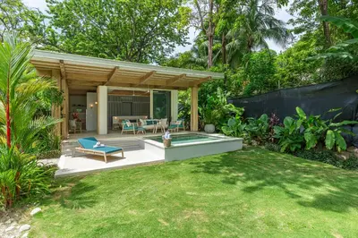 a backyard with a pool and a house at New Beachfront House - Casa Aura in Santa Teresa Beach