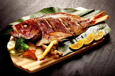 a fish on a plate with vegetables and lemon slices at Vista Celestial in Uvita