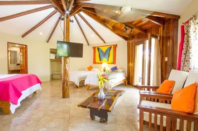 a large room with two beds and a tv at Tamarindo Village Hotel in Tamarindo