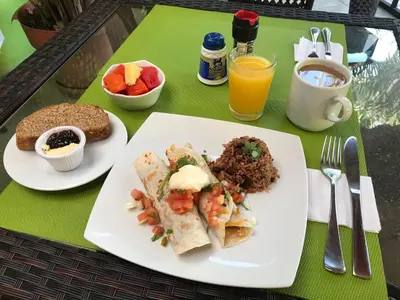 a table with two plates of food on it at Tamarindo Village Hotel in Tamarindo