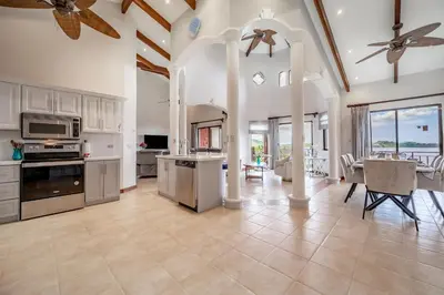 a large kitchen with white cabinets and a dining room at Villas Catalina 7 in Potrero