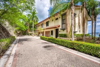 a house with palm trees and a driveway at Villas Catalina 7 in Potrero