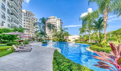 a swimming pool with palm trees and buildings at Jaco Bay 4903 Three bdrm Suite Spectacular Views Pool in Jacó