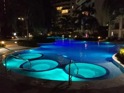 a swimming pool lit up at night with blue lights at Jaco Bay 4903 Three bdrm Suite Spectacular Views Pool in Jacó