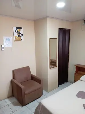 a bedroom with a chair and a mirror at HOSTEL CASA MARINA in Puerto Limón