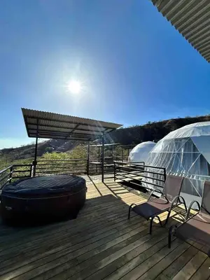 a deck with a tub and a chair and a tent at Glamping en Playa Potrero in Potrero